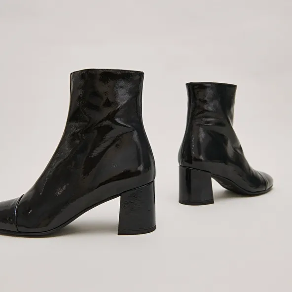 Heeled boots in black pleated patent